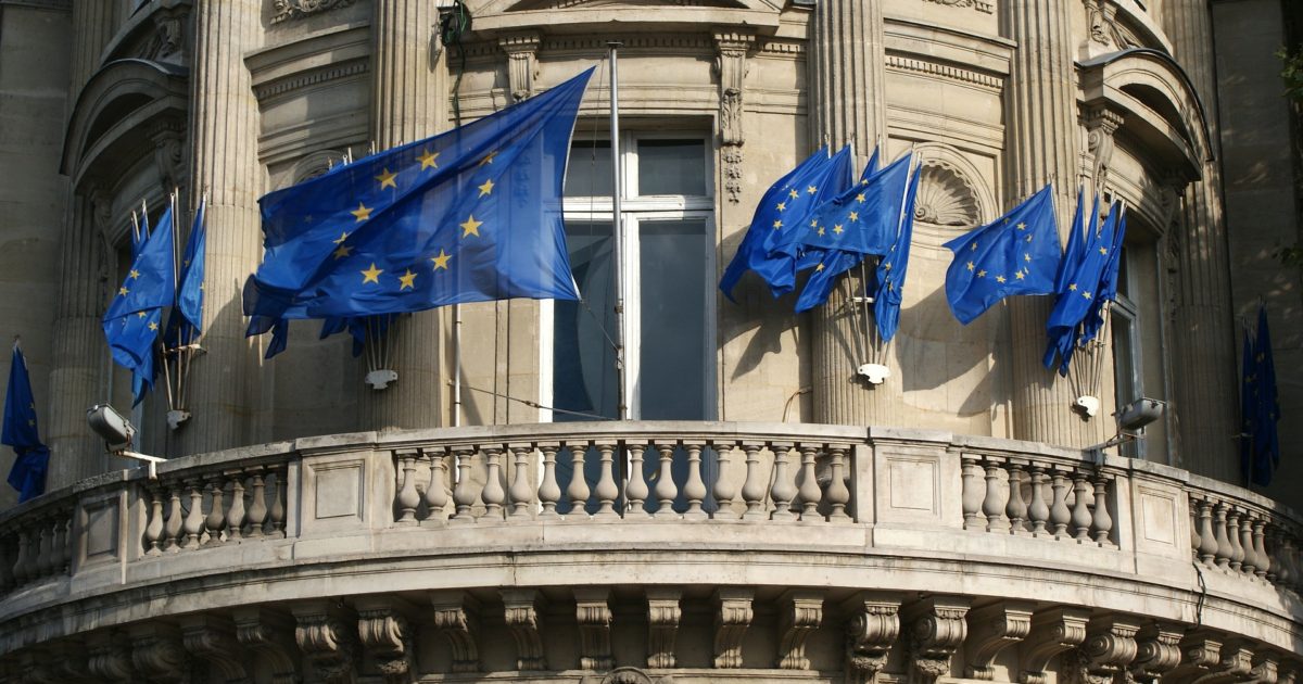 european union flags on building by David Mark